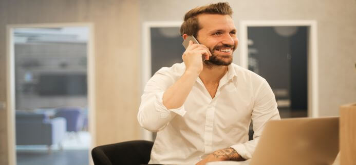 A happy man in a long-distance relationship speaking with partner