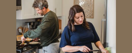 A man in the kitchen with the wife defying the gender role