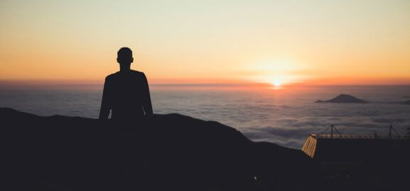 Man with insatiable curiosity standing in awe at the sunset