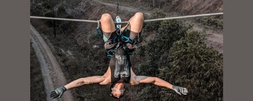 A man hanging on a rope many meters above the ground exhibiting toxic masculinity