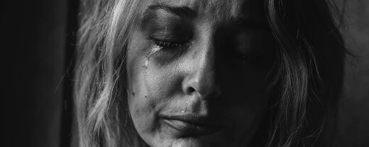 A crying woman who is passing through the 7 signs of trauma bonding