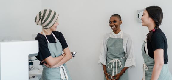 Co-workers in aprons witty bantering away