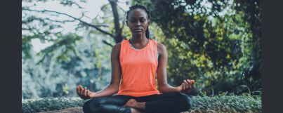 A lady in a serene environment practicing mindfulness meditation techniques for beginners