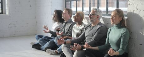 Coworkers practicing mindfulness in the workplace to answer the question: How can mindfulness help in the workplace?