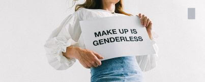 A man holding up a "make up is genderless" memo in demonstration of the impact of gender stereotypes on individuals