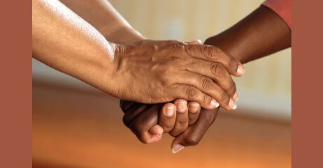 Two hands assuring each other, demonstrating trust as a power emotion used in persuasion